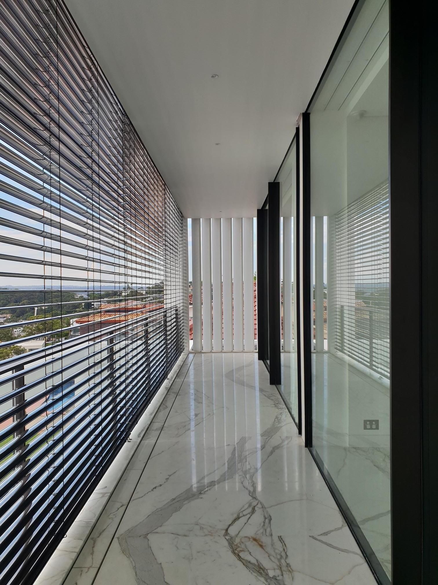 External venetian blinds on a window overlooking the hill