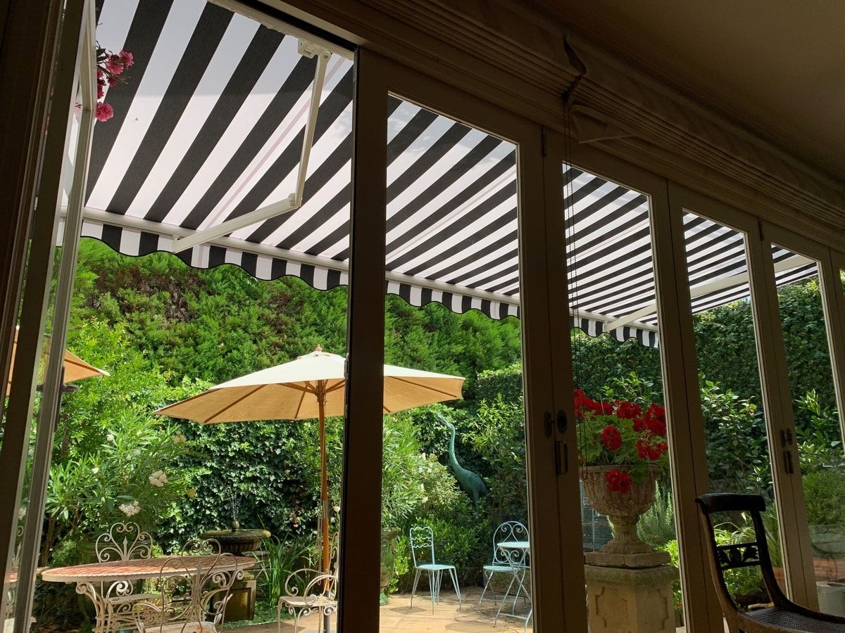 Inside view looking out of H60 awning opened over a residential courtyard